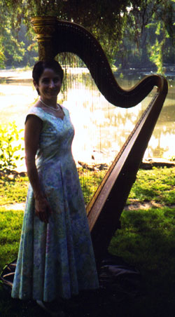Stephanie Bennett with her harp at a lakeside wedding